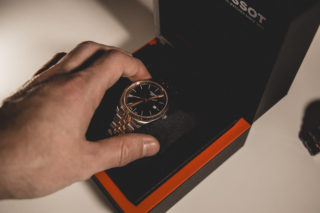 hand-placing-a-gold-watch-into-a-black-box-rvhn4bneppm